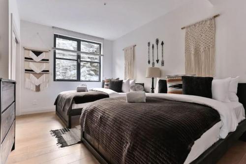 a large bedroom with two beds and a television at 101 Horizon - 3 Bdrs Tremblant Ski In Out plus Spa & Sauna in Mont-Tremblant