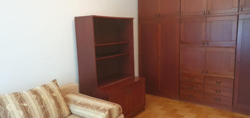 een woonkamer met een bank en een boekenplank bij Przytulne mieszkanie m3 Gorlice in Gorlice