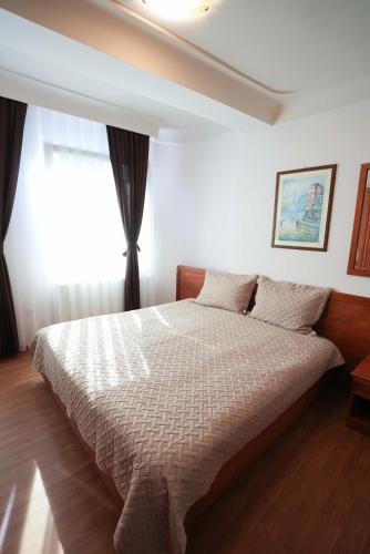 a bedroom with a bed and a window at Hotel Gold Inn in Peje