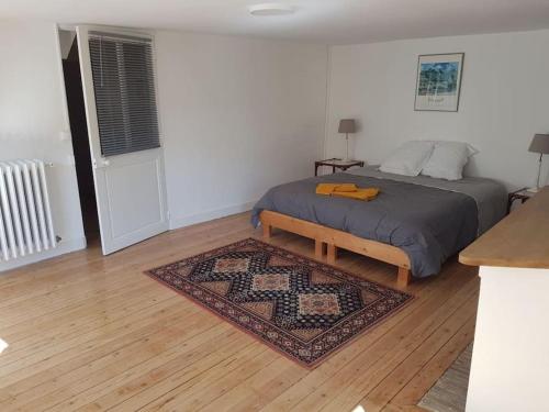 sypialnia z łóżkiem i dywanem na drewnianej podłodze w obiekcie Côté Château w mieście Chinon