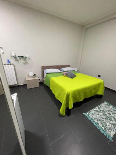 a bedroom with a bed with a yellow blanket on it at Tufaro B&B Private Room in Macerata Campania