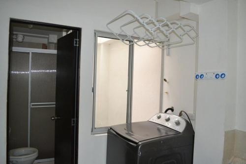 een badkamer met een koffer in de hoek van een kamer bij GURUS FR | Apartamento cerca al Aeropuerto y Terminal 2 Hab in Pereira