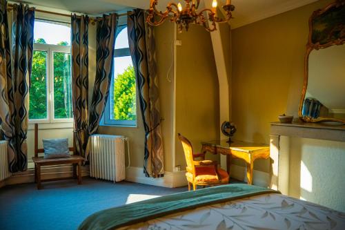 a bedroom with a bed and a desk and a window at Chambre au Château de St-Pierre-Brouck in Saint-Pierre-Brouck