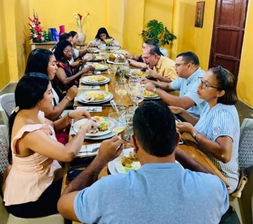 Un gruppo di persone seduti intorno a un tavolo che mangiano cibo di Hotel Majestic Mompox a Mompós