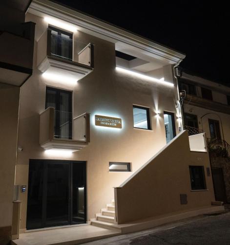a building with lights on the side of it at night at Harmony Tropea Rooms & Suites in Tropea