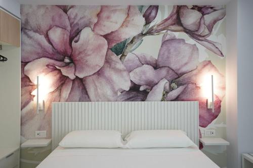 a bedroom with a flower mural on the wall at Harmony Tropea Rooms & Suites in Tropea