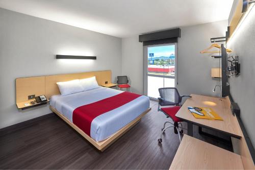 Habitación de hotel con cama, escritorio y escritorio. en City Express by Marriott Comitán, en Comitán de Domínguez