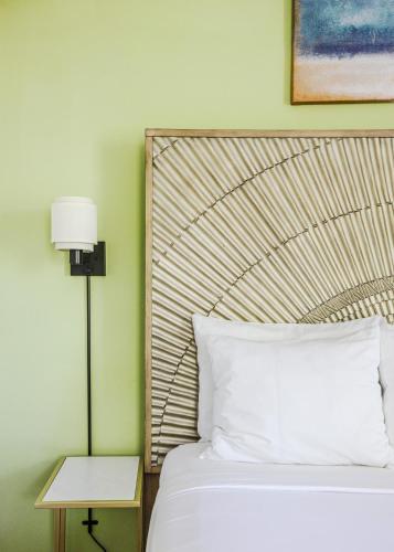 a bed with a white pillow and a lamp next to it at Princess Anne Boutique Hotel in Asheville
