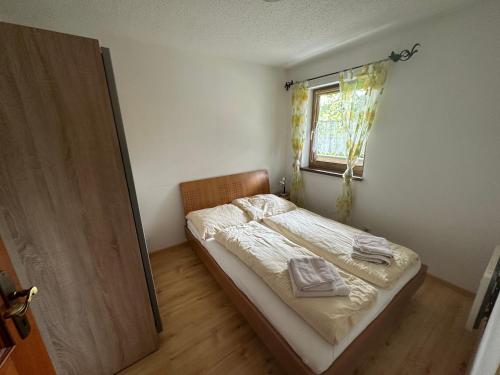 mała sypialnia z łóżkiem i oknem w obiekcie Landhaus Erharter w mieście Kitzbühel
