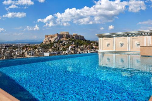 a large swimming pool with a view of a city at Hotel Grande Bretagne, a Luxury Collection Hotel, Athens in Athens