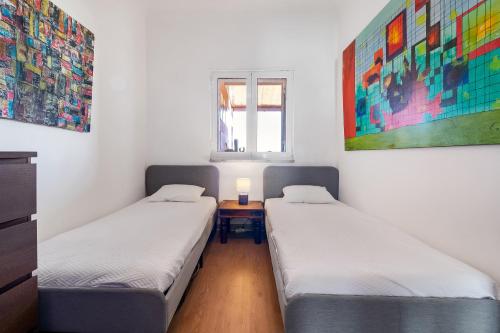 2 camas en una habitación con mesa y ventana en Tavira Balsa Romana - Luz de Tavira en Luz de Tavira