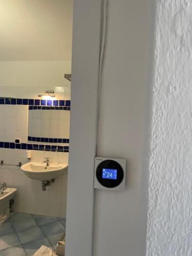 a bathroom with a clock on the wall at VILLINO FIORI DI BARAGGE in Palau