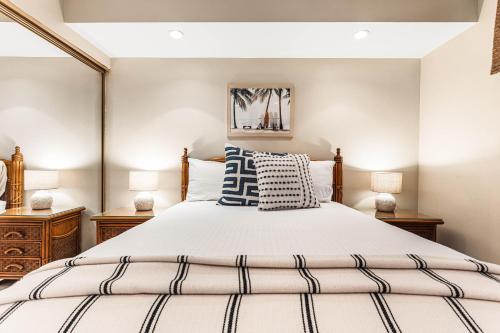 a bedroom with a large bed and two lamps at Noelani 104 in Kahana