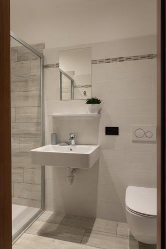 a white bathroom with a sink and a toilet at Albergo San Michele in Tirano