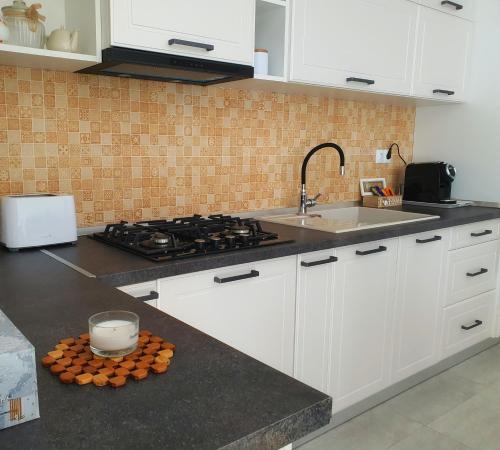 a kitchen with white cabinets and a sink and a stove at Minas Dream in Floreşti