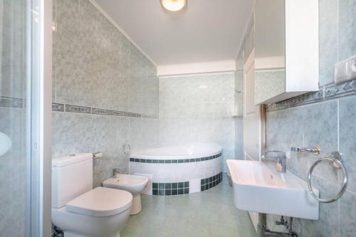 La salle de bains est pourvue de toilettes, d'un lavabo et d'une baignoire. dans l'établissement Okouzlující vila u jezera Lhota, à Lhota