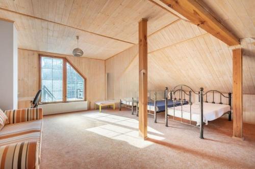 a bedroom with two beds in a room with a large window at Okouzlující vila u jezera Lhota in Lhota