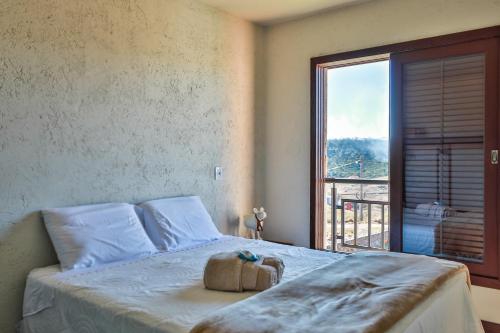 ein Schlafzimmer mit einem Bett mit einer Tasche darauf in der Unterkunft Alvorada dos Cânions - Altos da Serra in Bom Jardim da Serra