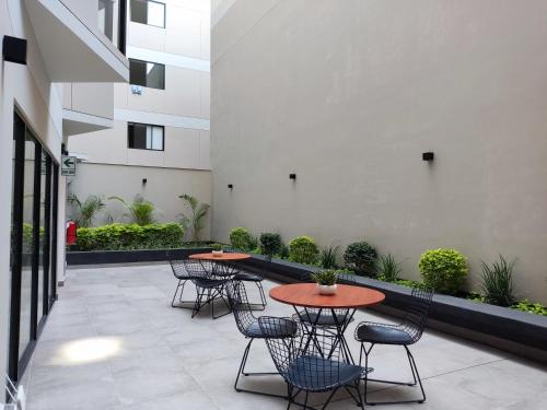 a patio with tables and chairs in a building at El Sol by Wynwood House in Lima