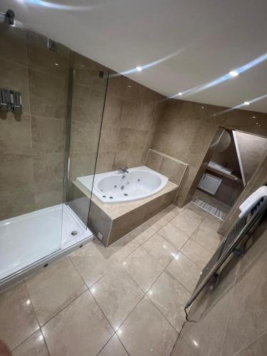 a large bathroom with a tub and a shower at Cosy 3-Bed house in Clydach - TV in every bedroom! in Clydach