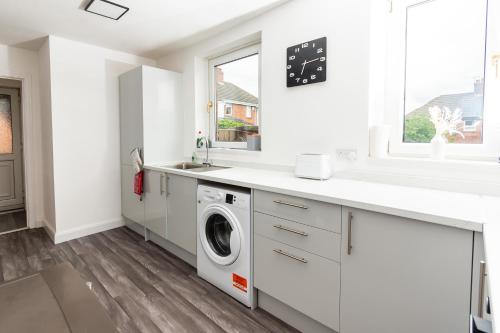 a white laundry room with a washer and dryer at Greenbourne - 4 bedrooms Sleeps 8 free parking in Gateshead