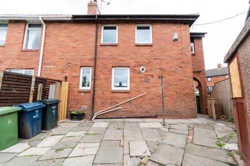 a red brick building with a courtyard in front of it at Greenbourne - 4 bedrooms Sleeps 8 free parking in Gateshead