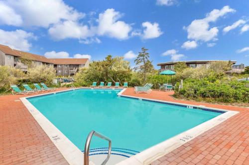 AmagansettUnit 1925 Ocean Colony Beach的一个带椅子的大型游泳池和一栋建筑
