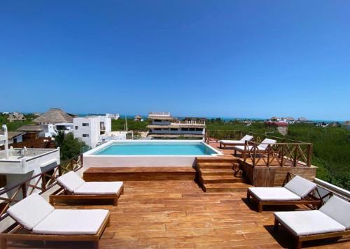 un patio avec des chaises et une piscine dans un bâtiment dans l'établissement sunsteps dragonfly room, à Holbox