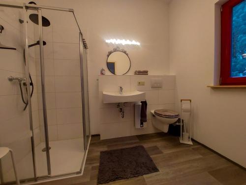 La salle de bains est pourvue d'une douche, d'un lavabo et de toilettes. dans l'établissement Ferienbungalow "Outdoor", à Bad Schandau
