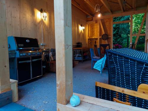 eine Veranda einer Hütte mit einem Herd und einem Tisch in der Unterkunft Ferienbungalow "Outdoor" in Bad Schandau