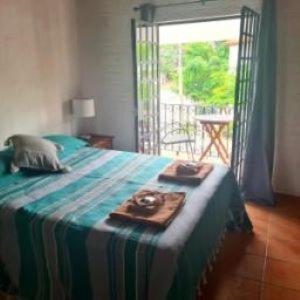 a bedroom with a bed with a table and a window at Casa Gemelas in Puerto Vallarta