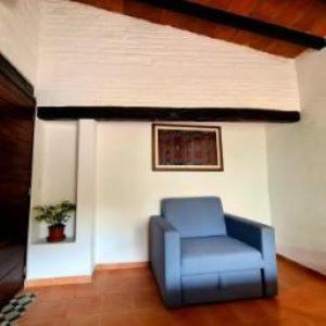 a blue chair in a room with a wall at Casa Gemelas in Puerto Vallarta