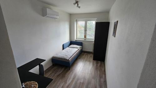 Habitación pequeña con cama y ventana en Penzión Alexandra en Hokovce