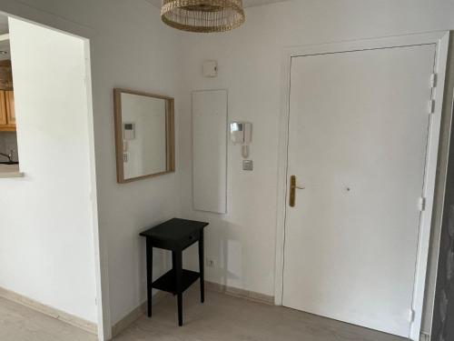 Cette chambre comprend une porte, un tabouret et un miroir. dans l'établissement Mandelieu apartment, à Mandelieu-la-Napoule