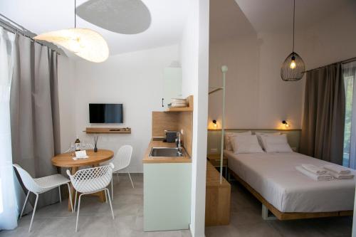 a hotel room with a bed and a table and a sink at Arodo Suites in Iraklitsa