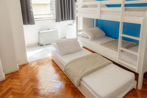 two bunk beds in a room with wooden floors at Excepcional 2 quartos Copacabana a 100m da praia in Rio de Janeiro