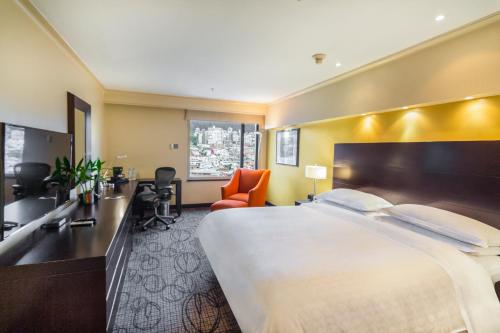 キトにあるSheraton Quitoの大きなベッドとバスルームが備わるホテルルームです。
