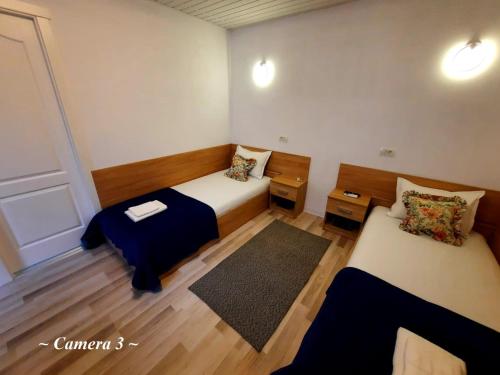 Kleines Zimmer mit 2 Betten und einem Teppich in der Unterkunft Bucharest Wheel View in Bukarest