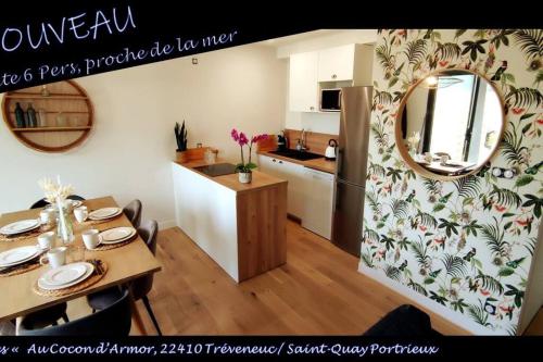 - une cuisine et une salle à manger avec une table et un miroir dans l'établissement Gîte familial proche plages « Au Cocon d’Armor », à Tréveneuc