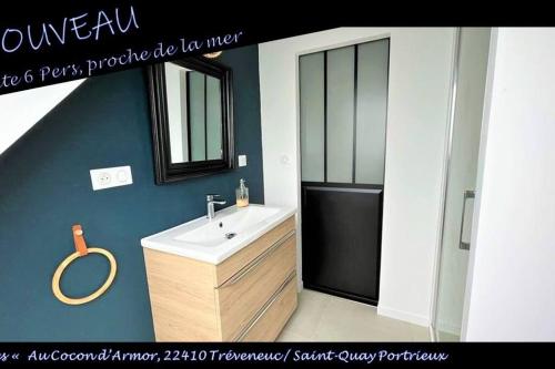une salle de bain avec un lavabo et un miroir dans l'établissement Gîte familial proche plages « Au Cocon d’Armor », à Tréveneuc