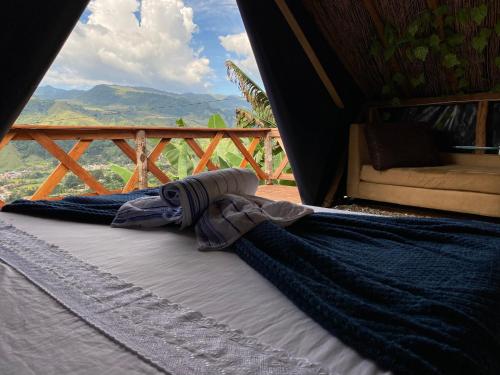 a bed in a tent with a view of the mountains at Origlamping Noche De Luna in Jardin