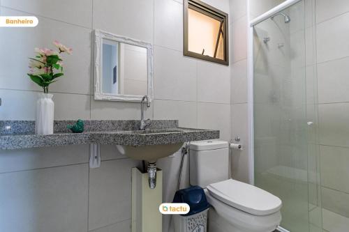 y baño con lavabo, aseo y espejo. en Apartamento vista mar VG Sun Cumbuco por Tactu, en Cumbuco