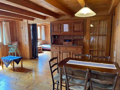 a dining room with a table and chairs in a cabin at Appartamento accogliente di montagna a Cavagnago in Faido