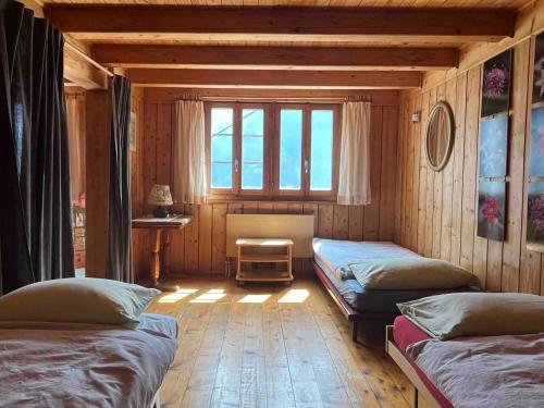 Zimmer mit 3 Betten und einem Fenster in der Unterkunft Appartamento accogliente di montagna a Cavagnago in Faido