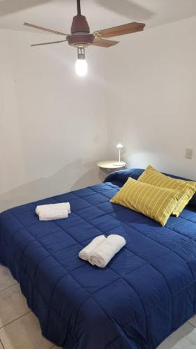 Una cama azul con dos toallas encima. en Departamento Aristobulo en La Cieneguita