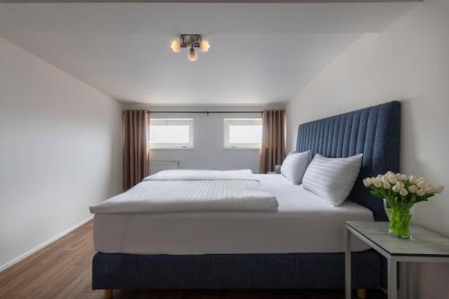 a bedroom with a bed with a blue headboard and a table at Prague Tales Boutique Residence by Dwellfort in Prague