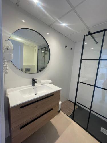 La salle de bains est pourvue d'un lavabo et d'un miroir. dans l'établissement Jardines Del Puerto, à Marbella