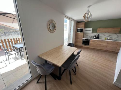 une cuisine et une salle à manger avec une table et des chaises en bois dans l'établissement Appartement centre ville * terrasse * clim * WIFI * Haut de gamme *, à Angoulême