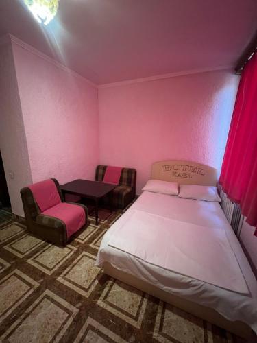 a bedroom with a bed and chairs and a table at Touristic House KAEL in Musalerr