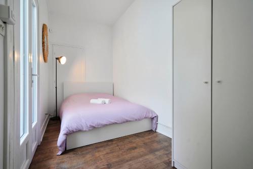 une petite chambre avec un lit rose et une fenêtre dans l'établissement Appartement cosy au centre de Lille, à Lille